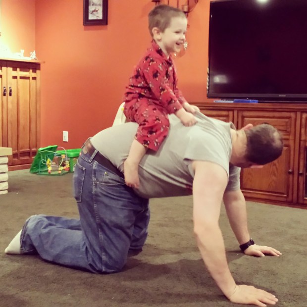 Cricket riding Daddy around the room proved easier to capture than a nice picture of everyone in front of the Christmas tree.